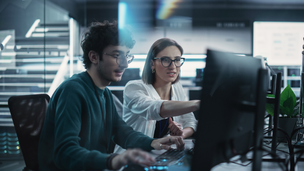 Colleagues working together at a computer monitor