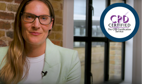 Female presenter looking to caemra with a CPD certification logo on screen