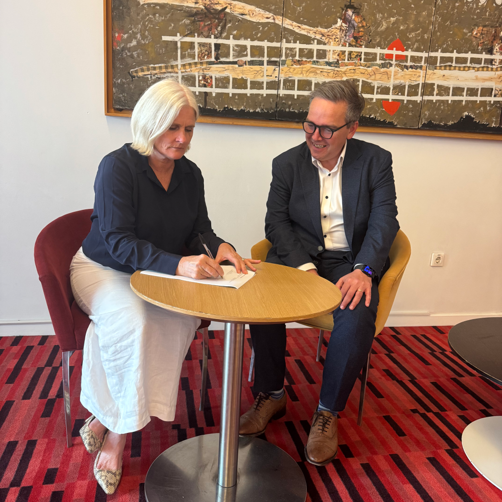 A photo of CLA CEO Simon Hutson and Josephine Johnston CEO of Copyright Agency signing an amendment to long standing partnership to include Generative AI Workplace permissions